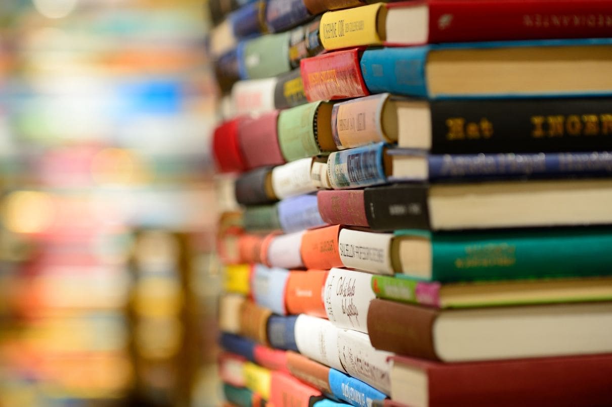 A stack of books neatly arranged in a bookstore, showcasing a variety of titles and genres.
